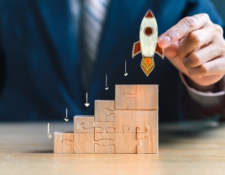 startup business launch strategy shown by a hand placing a glowing rocket puzzle piece onto a corporate foundation hierarchy
