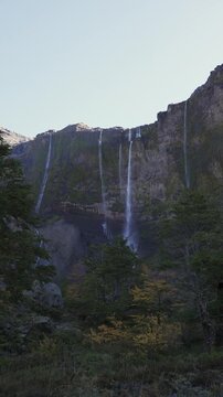 Casta&ntilde;o Overa glacier and cascading waterfalls flowing down a rocky cliff in Nahuel Huapi National Park, Argentina, showcasing glacial ice and mountain water.