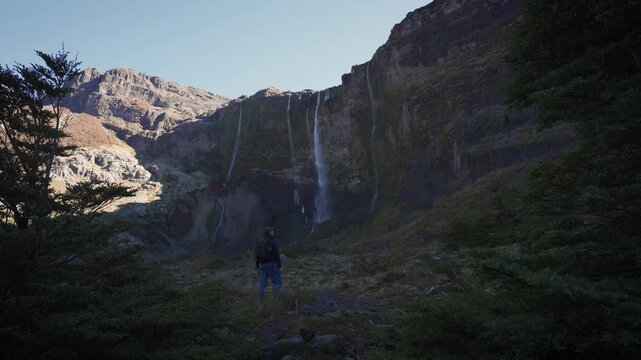 Hiker observing Casta&ntilde;o Overa glacier waterfalls in Nahuel Huapi National Park, Argentina