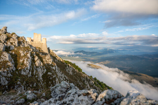 Historic Rocca Calascio fortress stands majestically on a mountain ridge above the clouds in Italy