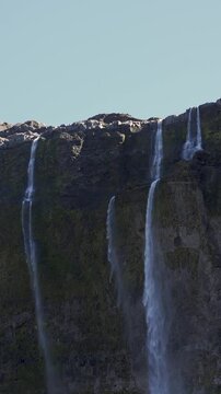 Casta&ntilde;o Overa glacier and cascading waterfalls flowing down a rocky cliff in Nahuel Huapi National Park, Argentina, showcasing glacial ice and mountain water.