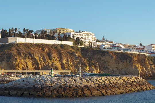 Porto de Abrigo in Albufeira, Algarve, during sunset with buildings on the cliff