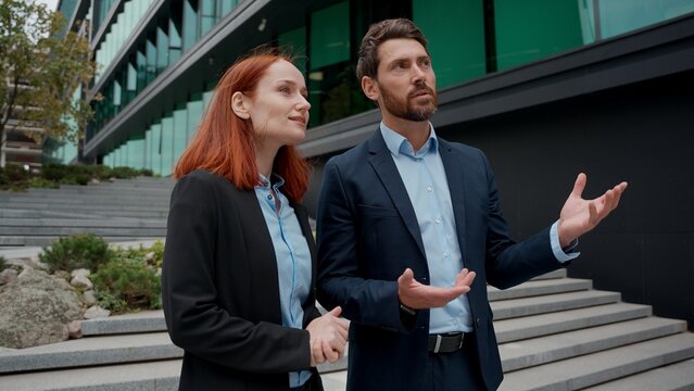 Two Caucasian business partners woman man meeting in city shaking hands discuss businesspeople office building entrepreneurs adult businessman businesswoman handshaking talking investors urban invest