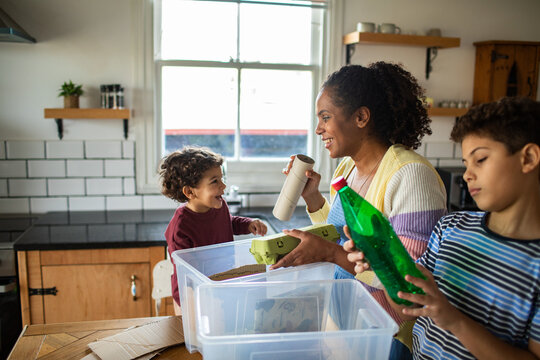 Family recycling together in home kitchen