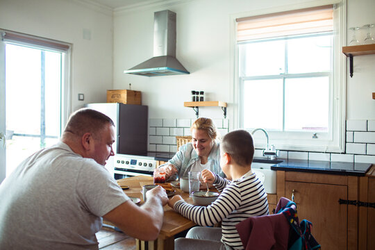 Family eating breakfast together in home kitchen