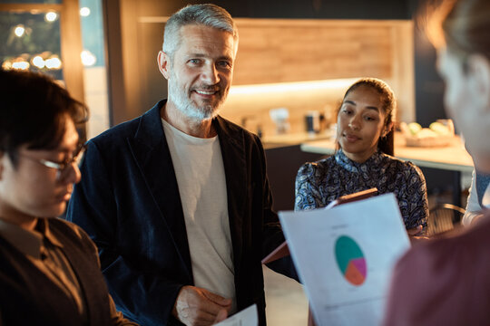 Coworkers reviewing charts in modern office meeting