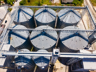 Large grain silos in an agricultural area are seen from above, surrounded by fields and infrastructure in a rural setting © DSMT