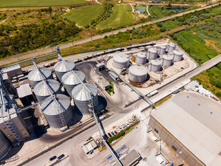 Grain storage facility located near the countryside with silos and transportation trucks in operation © DSMT
