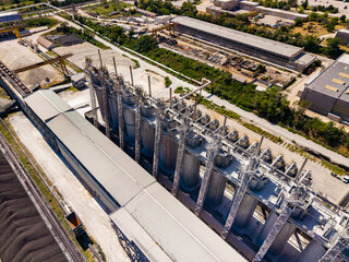 Large industrial facility with silos and buildings in a rural area during daytime © DSMT