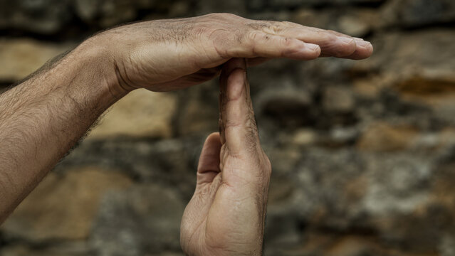 Closeup of a person making a timeout gesture with their hands.
