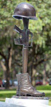 SAVVANAH GEORGIA USA: Vietnam War Memorial, a bronze helmet, rifle, and pair of combat boots to honor fallen comrades. Emmet Park, Savannah,