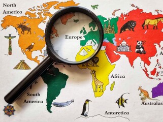 Magnifying glass zooming in on Europe on a colorful illustrated world map with global landmarks. © RJuniantoro_