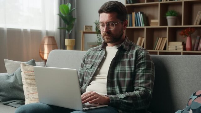 Caucasian freelancer business man at home using laptop typing working thinking adult businessman male author journalist user writing article computer internet online guy ponder web job order decide