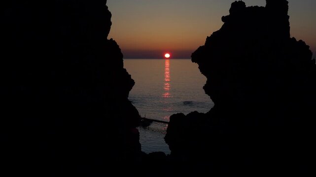 ウトロの海岸線の奇岩の間に沈む夕陽