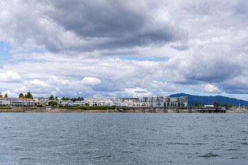Obraz premium Stormy Sky Over Waterfront Homes and Pier in Sidney on Vancouver Island, BC Canada