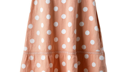 Isolated close up of peach-colored polka dot fabric with smocked detail on skirt or dress hem. © Andrei