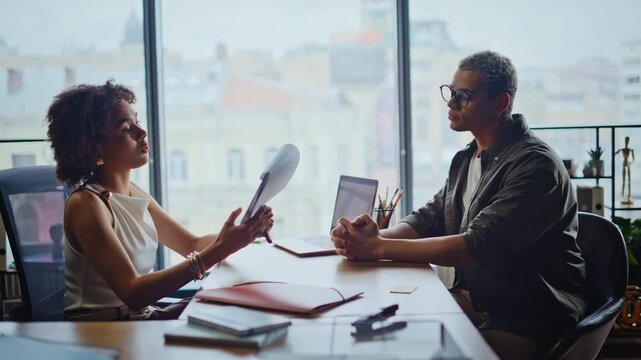 Businesswoman presenting document to man in office meeting negotiating deal