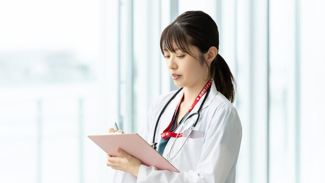 医療記録を確認する女性医療スタッフ, Female Medical Professional Reviewing Medical Records