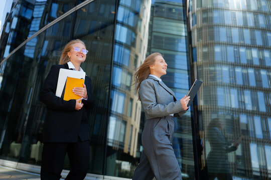 Businesswomen stroll confidently in a modern city, embracing the vibrant energy of their surroundings