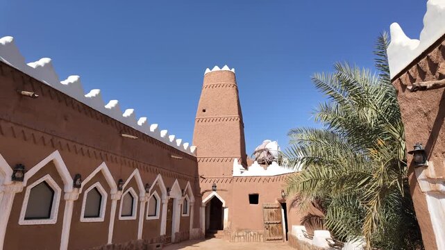 Ushaiqer Heritage Village interior featuring Najdi mud-brick architecture with white columns, decorative arches and textured adobe walls preserving Saudi Arabia's cultural past of Arabs