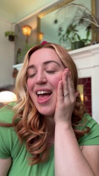 woman checks out her face in the mirror and is happy with her skincare routine