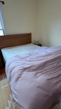 removing dirty sheets and blankets from the bed, stripping the bed