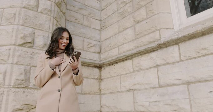 A young woman on a bicycle scrolls through her phone and opens a message, reacting with joyful surprise and excitement. A victory notification and confirmation of a long-awaited event.