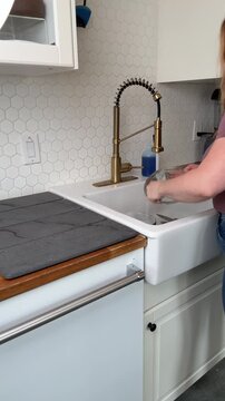 person washing dishes in the sink