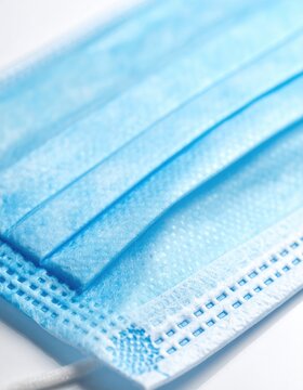 Close-up of a pleated blue disposable medical face covering