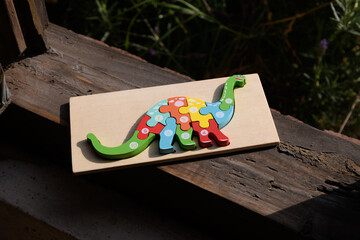 Colorful Wooden Dinosaur Number Puzzle on Rustic Ledge © Luis Fernando Dávila