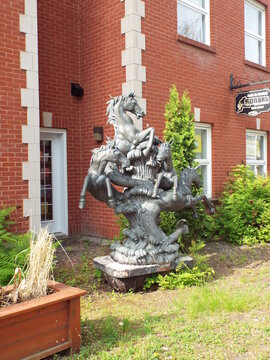 Gatineau,Quebec, Canada &ndash; June 4, 2026: The "bronze sculpture" depicting rearing horses with fishtails stands in front of a red brick building near the music school sign on rue Principale.
