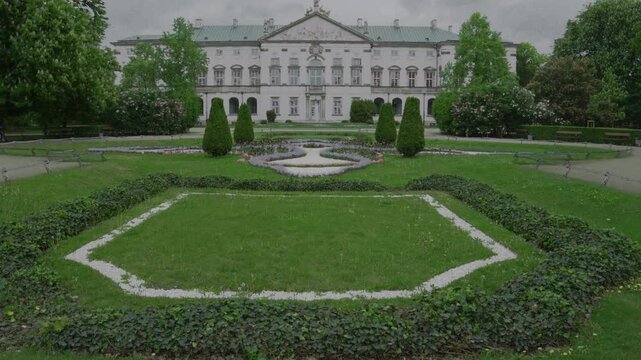 Vertical tilt-up shot from manicured garden lawns to the facade of the Palace of the Commonwealth in Warsaw, Poland.