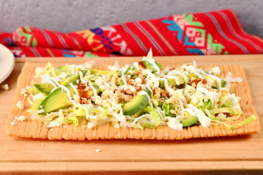 Chicharron preparado. Traditional Mexican cuisine served on wooden cutting board with vibrant napkin