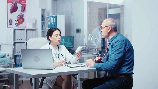 Doctor recommends pills to a senior patient in her office during a private clinic checkup, discussing medication, dosage and treatment.