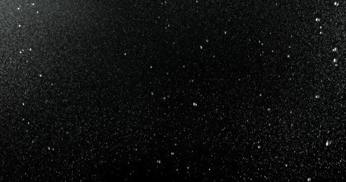 Ultra slow motion fine rain mist falling on a black background. High-quality VFX overlay for cinematic compositing, weather simulations, motion graphics, title sequences and visual effects.