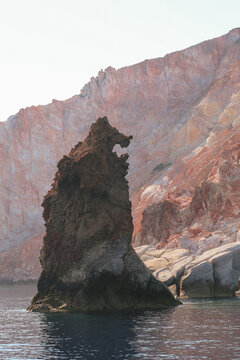 The Arkoudes rock formation, known as the Bear Rocks, stands near the entrance to Milos Bay, its volcanic shape resembling a bear gazing toward the Aegean Sea.
