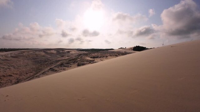 Cinematic slow panning shot showcasing the majestic white sand dunes landscape in Bau Trang, Binh Thuan, Vietnam. Crisp daytime view with smooth camera movement and warm sunlight.