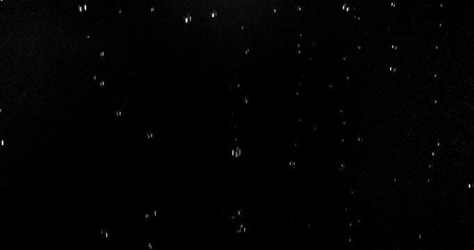 Ultra slow motion floating water droplets on a black background. Premium VFX overlay for cinematic compositing, motion graphics, title animations, trailers and professional visual effects.