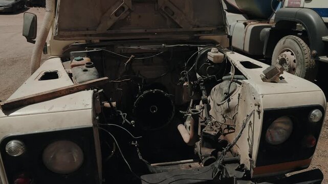 Open hood reveals stripped engine bay of an abandoned off road vehicle in Morocco