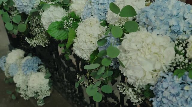 Lush white and blue hydrangeas with eucalyptus and baby breath in a wedding floral arrangement