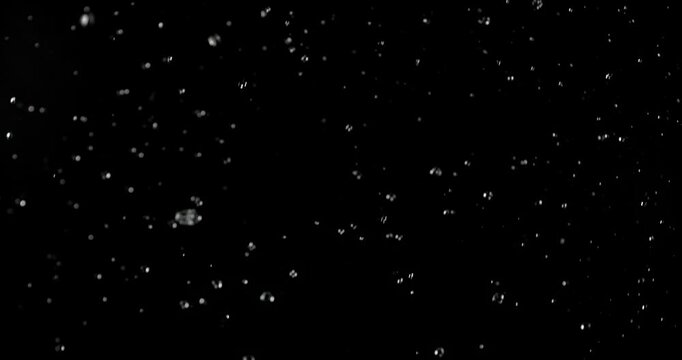 Ultra slow motion floating water droplets on a black background. Premium VFX overlay for cinematic compositing, motion graphics, title animations, trailers and professional visual effects.