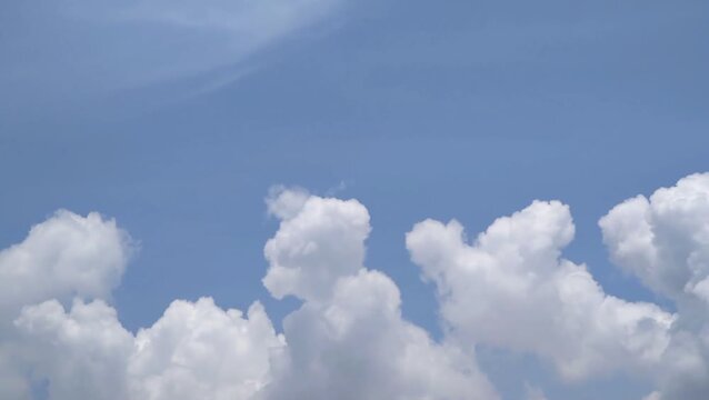 showing white cumulus clouds moving and disappearing slowly in the bright blue sky during the day. Showing natural beauty that is calm, peaceful and full of positive energy.
