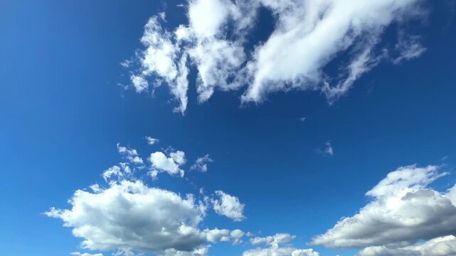 Witness the beauty of nature through a time-lapse of the movement of white clouds over a very bright blue sky. displays a peaceful, calm and refreshing daytime atmosphere.