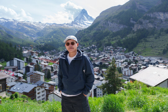 man Tourist Exploring Zermatt, Switzerland. Happy Traveler Visiting Zermatt Village Viewpoint and Matterhorn, Famous European Landmark, Popular Tourist Attraction and Travel Destination in Europe