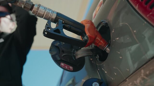 Diesel nozzle inserted into a car fuel filler neck during refuelling at a station