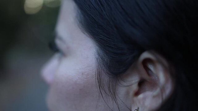Cinematic close-up shot of a young woman gazing thoughtfully outdoors, soft natural light highlighting her features, background artistically blurred for depth and dreamy mood.