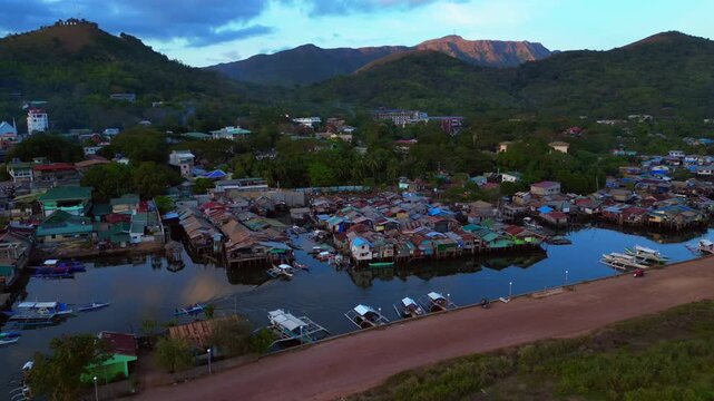 slum Houses on stilts forming an informal settlement along the coastline of Coron, Palawan, showing poverty and urban sprawl. Lovely aerial view panorama drone overview