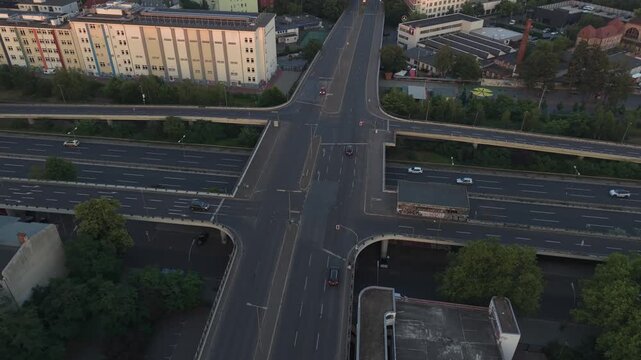 Berlin roads and bridges forming a multi level intersection, with cars moving through a cityscape. Fantastic aerial view fly reverse drone panorama