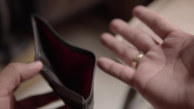 Closeup of empty wallet held in hands symbolizing financial crisis, money shortage, debt, and personal budget problems. Concept of poverty, hardship, and economic stress