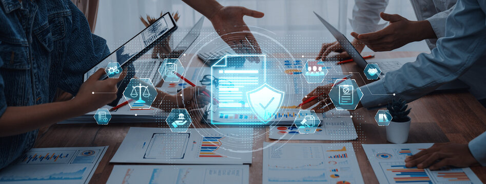 Business professionals engage in a collaborative meeting, analyzing data with digital security icons, showcasing innovative teamwork and effective strategies in a modern workspace. Trope